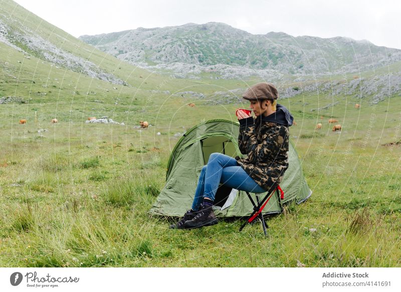 Frau in Oberbekleidung in der Nähe eines Campingzeltes in der Natur Lager Zelt Hochland Inhalt sich[Akk] entspannen Reisender Morgen Fernweh Freiheit Landschaft