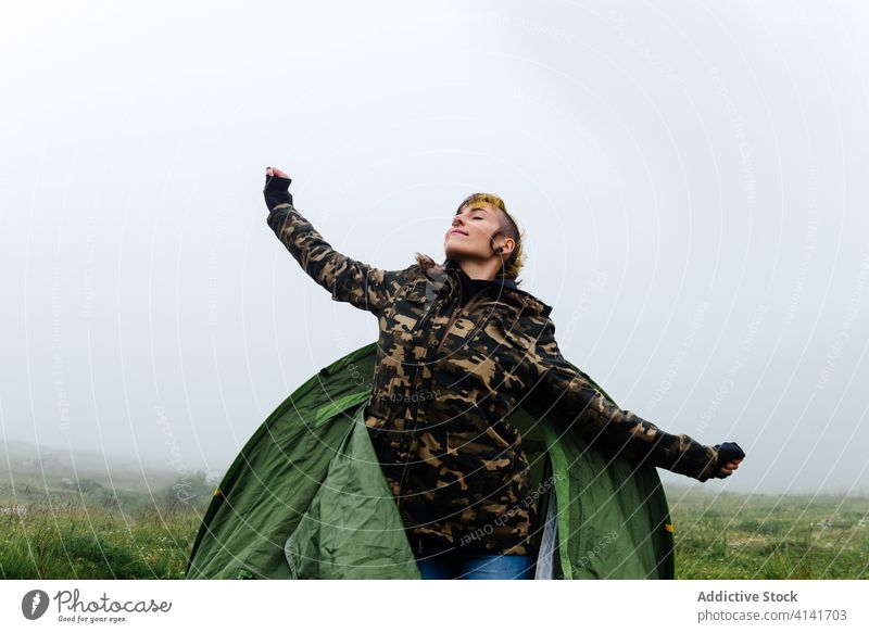 Zufriedene Frau streckt ihren Körper nach dem Schlafen im Campingzelt Dehnung Lager Zelt Natur Inhalt Reisender positiv Abenteuer Morgen Fernweh Freiheit