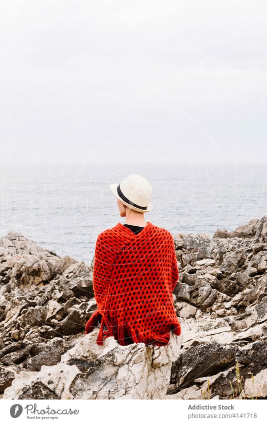 Stilvolle weibliche Touristin genießt die Meereslandschaft von einer felsigen Klippe aus Frau MEER Felsen sitzen Küste reisen genießen bewundern Natur Freiheit