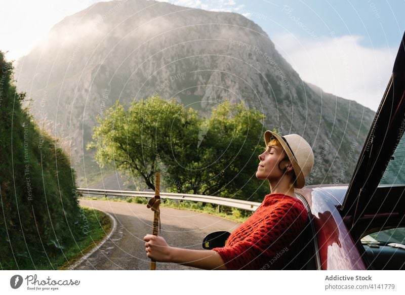 Ruhige Frau in der Nähe des Autos in den Bergen sorgenfrei Reisender Berge u. Gebirge Hochland Straße genießen PKW spektakulär Landschaft Urlaub Natur Verkehr