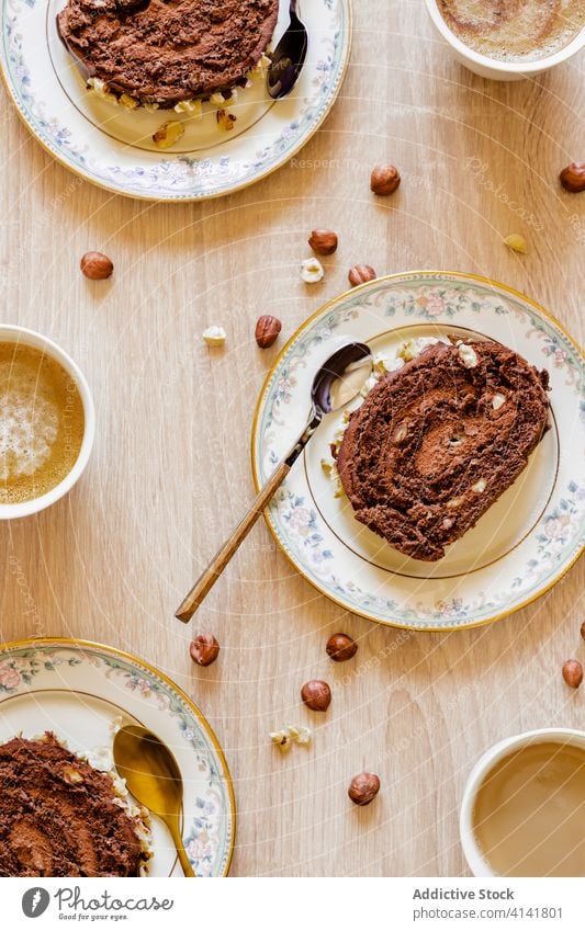 Schokoladenkuchen in Tellern auf dem Tisch Schweizer Brötchen Kuchen Portion lecker dienen Dessert Spielfigur Haselnuss selbstgemacht geschmackvoll süß rollen