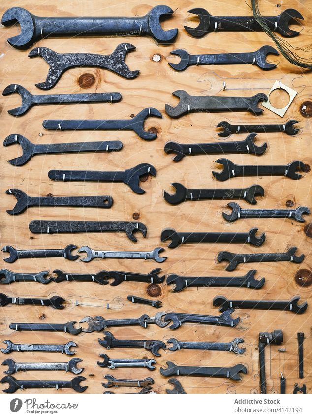 Holzwand mit einer Sammlung von Handwerksinstrumenten in der Werkstatt Kunstgewerbler Werkzeug Schraubenschlüssel Säge Rahmen einklemmen rechteckig Form anders
