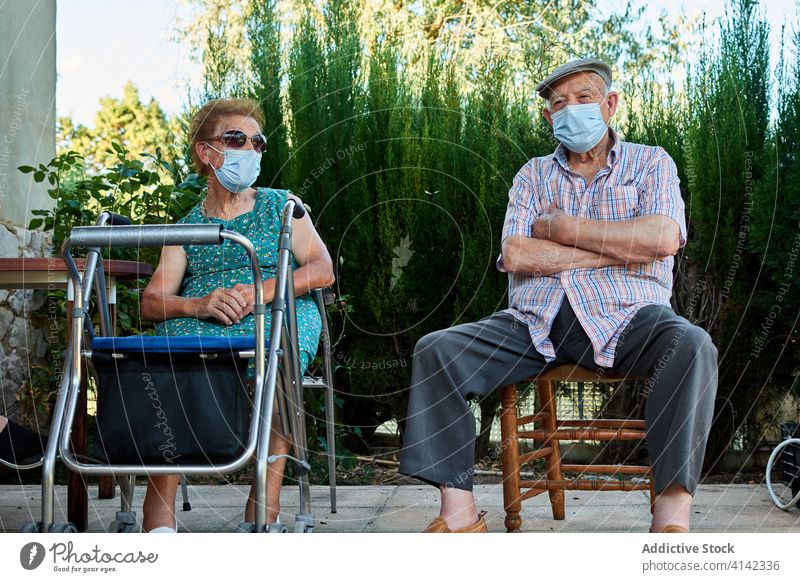 Gruppe von älteren Menschen sitzen auf der Terrasse des Hauses Senior Großeltern sich[Akk] sammeln Hof Zusammensein alt Mundschutz Coronavirus behüten COVID