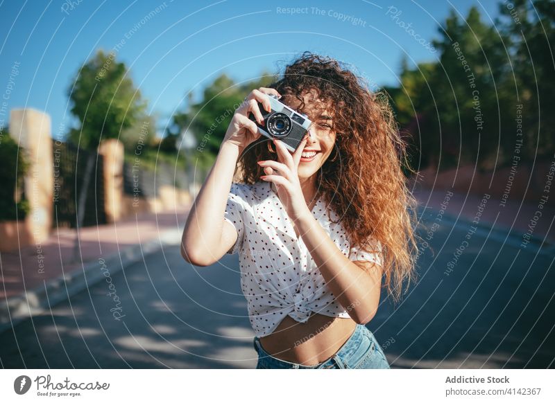 Glückliche Frau, die draussen mit der Kamera fotografiert fotografieren Fotoapparat digital Moment Sonnenschein heiter benutzend Gerät Hobby