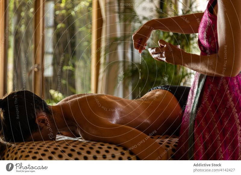 Anonyme Frau bekommt ayurvedische Behandlung auf dem Rücken ayurveda Erdöl heilen eingießen Massage bewerben Leckerbissen Therapie Verfahren Pflege