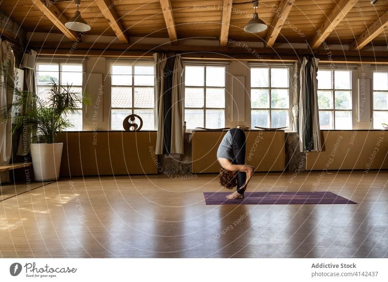 Flexible Frau in Uttanasana Yoga-Pose üben Asana Vorwärtsbeuge stehen uttanasana positionieren beweglich Gesundheit Konzentration Wellness Harmonie Vitalität