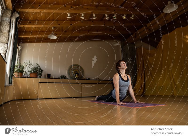 Frau in Kobra-Pose während einer Yoga-Sitzung üben Asana bhujangasana positionieren Gleichgewicht Fokus Wohlbefinden Gesundheit Konzentration Wellness Harmonie