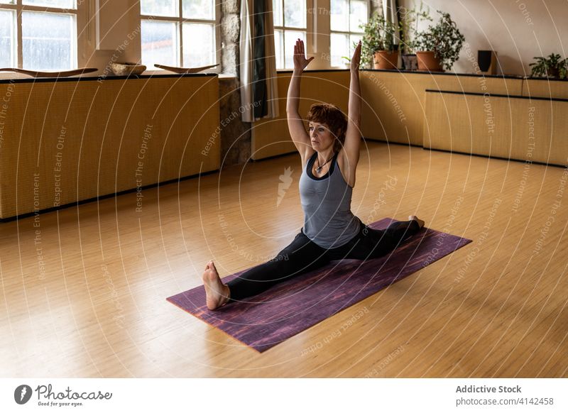 Flexible Frau übt Yoga-Pose im Studio üben Affen-Pose Asana sitzen Split beweglich hanumanasana fortgeschritten positionieren Wohlbefinden Gesundheit
