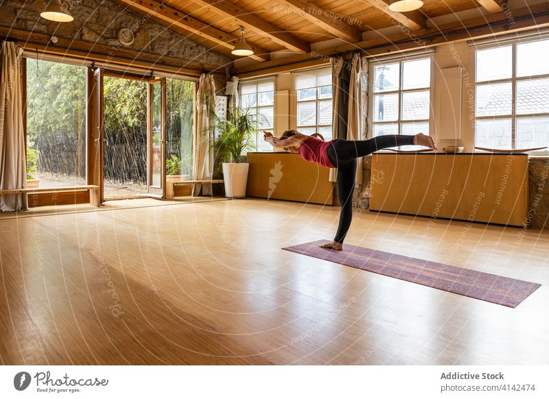 Schlanke Frau übt Yoga im geräumigen Studio üben Asana Drei-Krieger-Pose positionieren beweglich schlank Wegbiegung Gesundheit Konzentration Wellness Harmonie