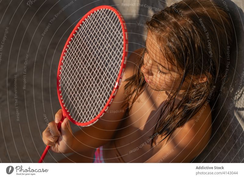 Kind mit Badmintonschläger im Innenhof Remmidemmi Schatten Sonnenlicht Hinterhof sonnig Windstille Gerät sitzen sich[Akk] entspannen tagsüber ruhen Wochenende