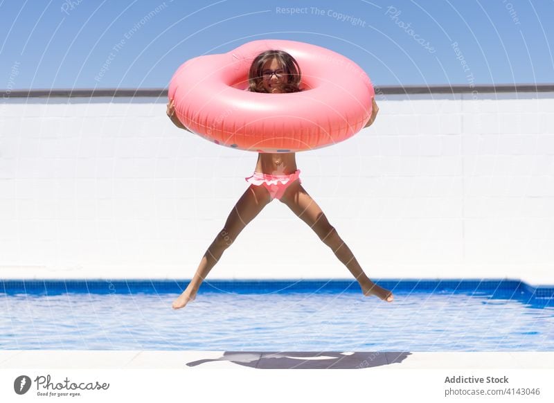 Glückliches Kind hat Spaß im Schwimmbad Pool Sommer aufblasbar heiter Spaß haben genießen Urlaub Mädchen Feiertag Wasser aufgeregt schwimmen Ring rosa Resort