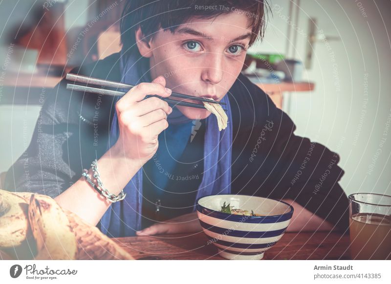 Junge isst asiatisches Essen mit Stäbchen Banane schön Schalen & Schüsseln lässig Kaukasier Essstäbchen selbstbewusst lecker Abendessen trinken Lebensmittel