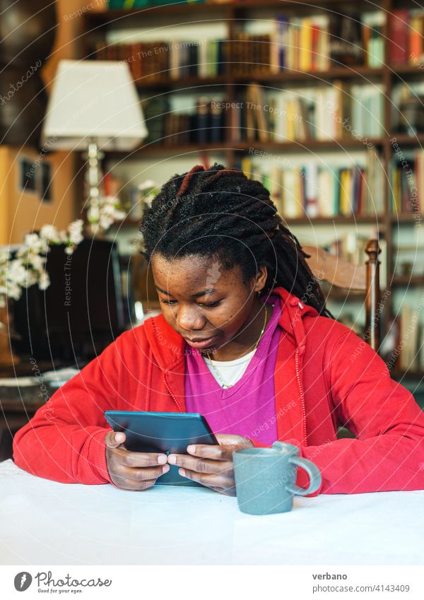 Teenager-Mädchen lernt online zu Hause aufgrund von Abriegelungsmaßnahmen afrikanische ethnische Zugehörigkeit Afroamerikaner App Anwendung Menschen Person