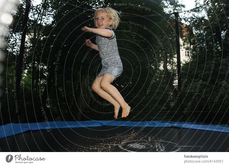 fröhlich springendes Mädchen auf einem Trampolin Kind Bewegung hüpfen Spielen Lebensfreude Kindheit Spaß Freude Fröhlichkeit spielen gesund fit Glück Sommer