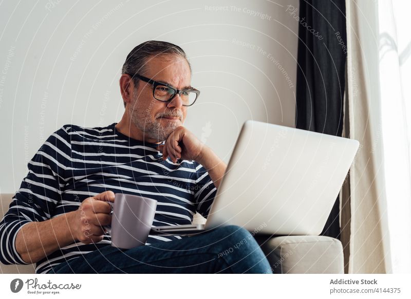 Erwachsener Mann trinkt Kaffee und benutzt Laptop Textfreiraum selbstbewusst Technik & Technologie Kaukasier Arbeit COVID19 Liege Mitteilung Coronavirus