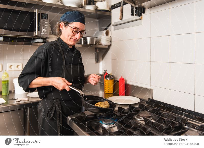 Koch bei der Arbeit mit einer Bratpfanne in einer Restaurantküche Lebensmittel Küchenchef Essen zubereiten Pfanne kulinarisch wirtschaftlich Hotel Feinschmecker