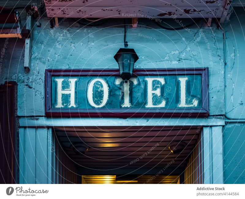 Hotelschild über einem schäbigen ländlichen Eingang blau rechteckig Zeichen Gebäude zeigen verwittert Tür Schild Panel Lampe gemütlich alt Nachricht Text Regie