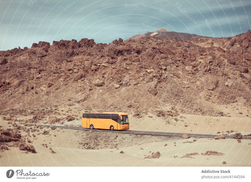 Bunter Bus, der bei Tageslicht auf einer trockenen, felsigen Straße fährt Berge u. Gebirge wüst Stein farbenfroh Himmel Hochland sandig Gelände Laufwerk hoch