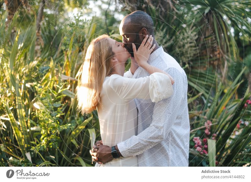 Romantisches buntes Paar küsst sich leidenschaftlich im abendlichen Garten Kuss Angebot romantisch Inhalt Umarmung Augen geschlossen Leidenschaft