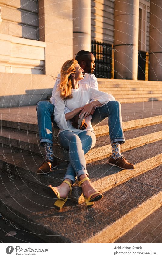 Romantisches Paar, das sich auf den Stufen eines alten Gebäudes in der Abendsonne ausruht Umarmung Bonden ruhen romantisch Inhalt Angebot Treppe Sonnenuntergang
