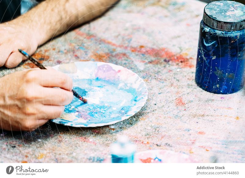 Fokussierter Künstler beim Mischen von Farben in einer Palette Mischung mischen Kunst Werkstatt Kleinunternehmen Konzentration Pigment Atelier Beruf Wasserfarbe