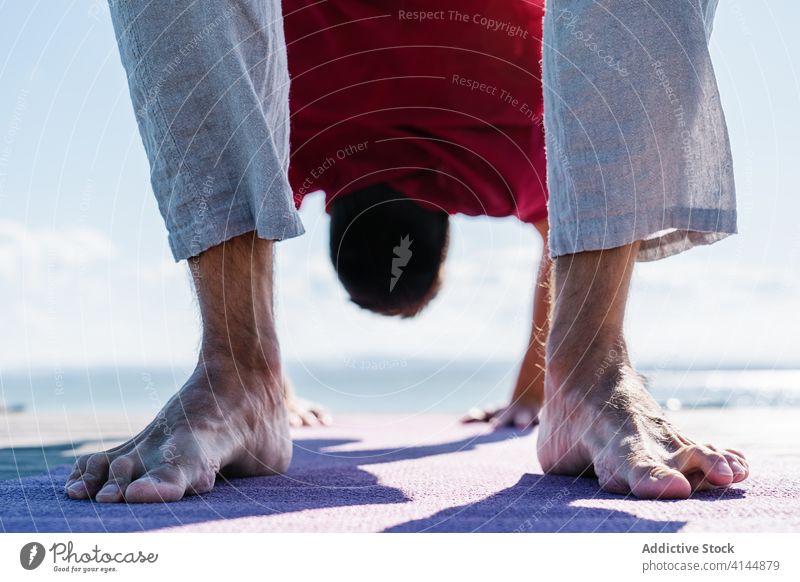 Barfüßiger Mann in Rad-Asana bei der Yoga-Praxis an der Strandpromenade urdhva dhanurasana auf den Kopf gestellt üben beweglich Gesundheit MEER Wellness