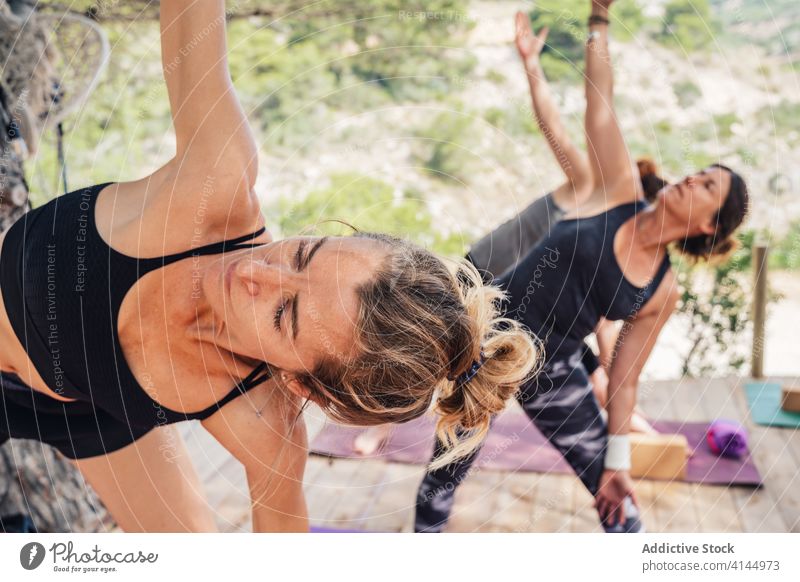 Gruppe von weiblichen Yoga-Schülerin tun Side Angle asana im Park Frauen Seitenwinkel parsvakonasana Klasse Gesundheit Gleichgewicht Dehnung Übung aktiv üben