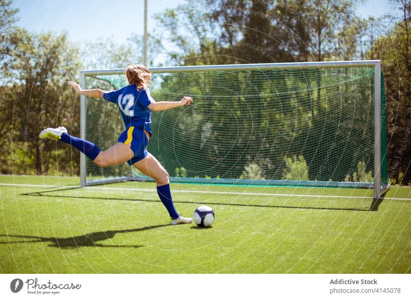 Anonyme Sportlerin, die den Ball ins Tor schießt Kick Fußball Feld Spiel professionell Training Frau Uniform Gras Aktivität Athlet Sportbekleidung punkten