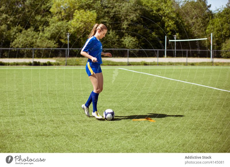 Weiblicher Fußballspieler auf dem Feld stehend Sportlerin bereit Training Ball Stiefel sonnig tagsüber Sommer Frau grasbewachsen Sportbekleidung Aktivität
