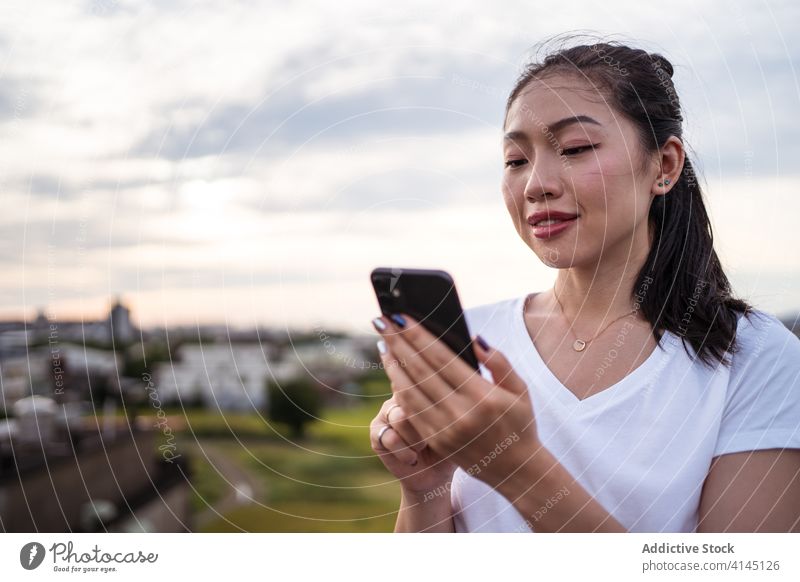 Chinesische Frau wählt ihren Freund per Smartphone aus Termin & Datum App wählen benutzend Terrasse ruhen Paar Lifestyle Browsen online Anschluss