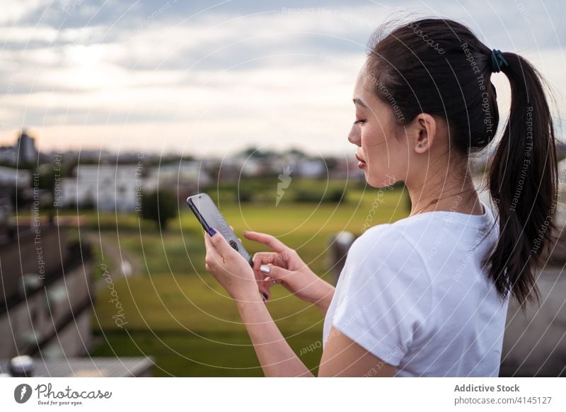 Chinesische Frau wählt ihren Freund per Smartphone aus Termin & Datum App wählen benutzend Terrasse ruhen Paar Lifestyle Browsen online Anschluss