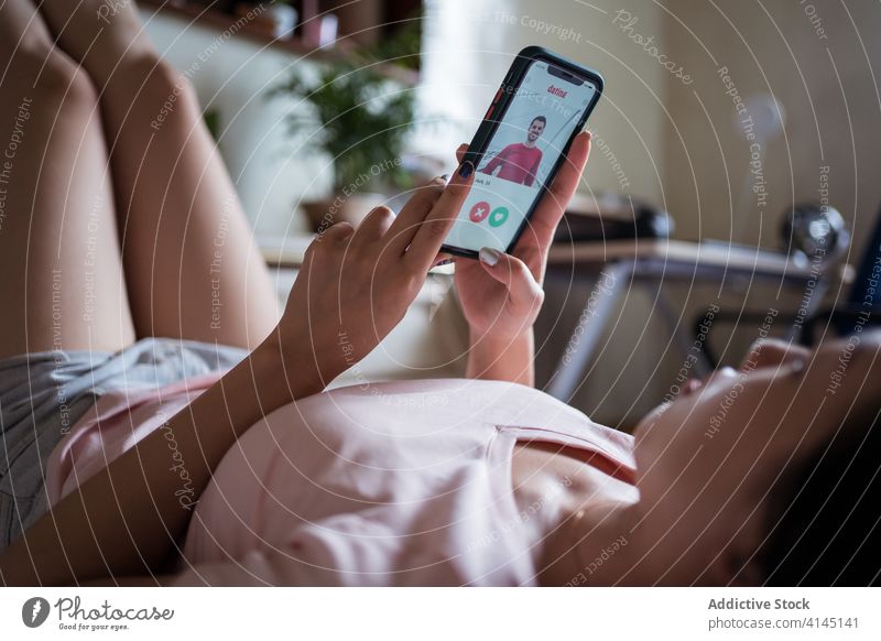 Asiatische weibliche Browsing Dating App auf Bett Frau Smartphone benutzend Termin & Datum wählen Streichholz heimwärts ruhen Liebe soziale Netzwerke Komfort