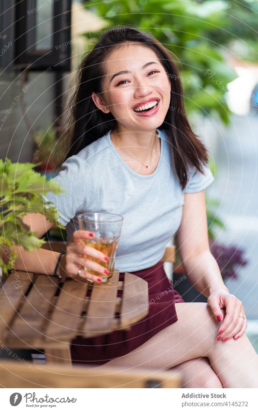 Entspannte ethnische Frau in Cafeteria Café trinken Wochenende genießen sich[Akk] entspannen Abfertigungsschalter Kantine Getränk Erfrischung asiatisch ruhen