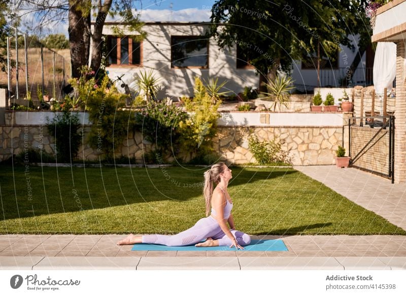 Flexible Frau übt Yoga in der Taubenhaltung üben meditieren Hinterhof beweglich Pose Asana ardha kapotasana Beckenrand Unterlage Gelassenheit