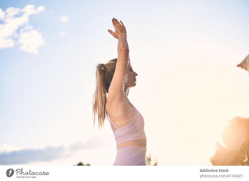 Frau macht Yoga in Bergpose im Park Berg-Pose Namaste üben Windstille Gelassenheit urdhva hastasana Sonnenuntergang gestikulieren Harmonie Asana friedlich
