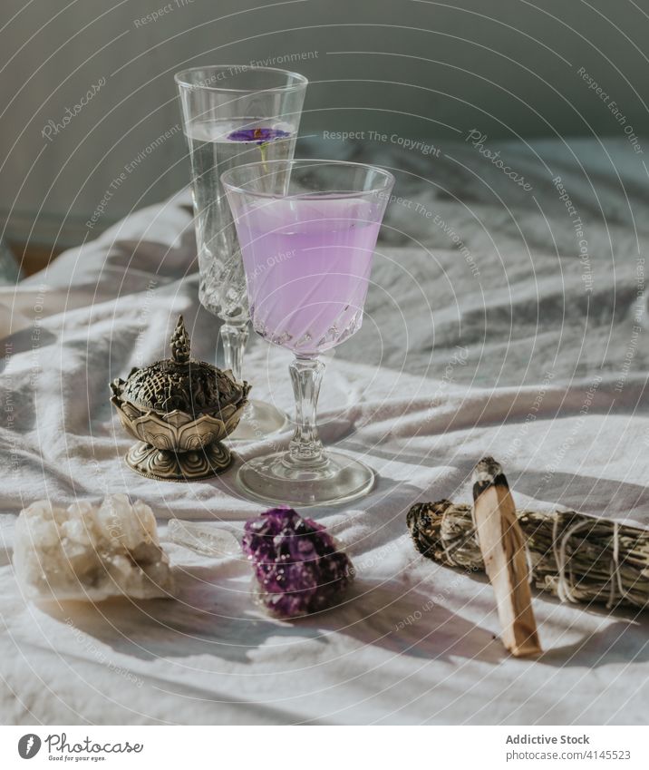 Natürliche Mineralien arrangiert mit Cocktails und Aromatherapiegeräten Quarz Amethyst natürlich Glas Brenner Tischwäsche Schatten Zusammensetzung schön Spa