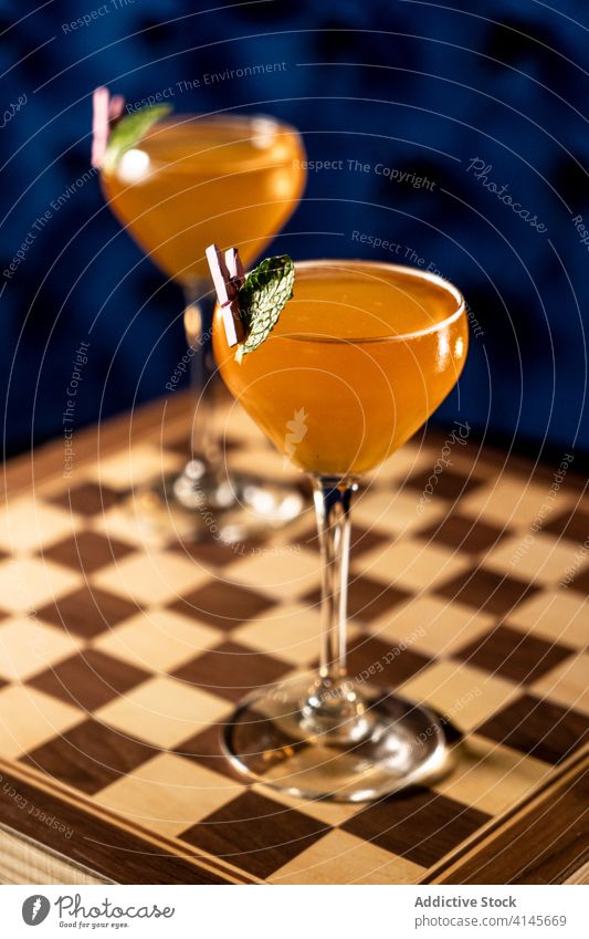Cocktailgläser auf Schachbrett Glas Alkohol Bar dienen Minze Blatt trinken frisch Frucht Getränk Erfrischung Saft kalt tropisch Schnaps Party Zusammensetzung