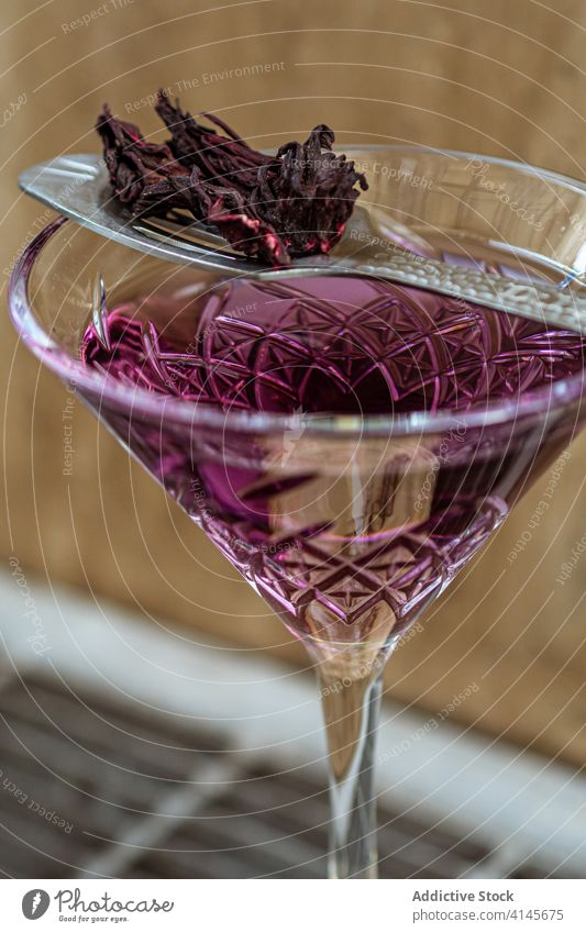 Löffel mit getrockneten Blütenblättern auf Cocktail Glas Blütenblatt Blume Dekor dienen Bar violett Kelch elegant natürlich trinken Getränk Alkohol frisch