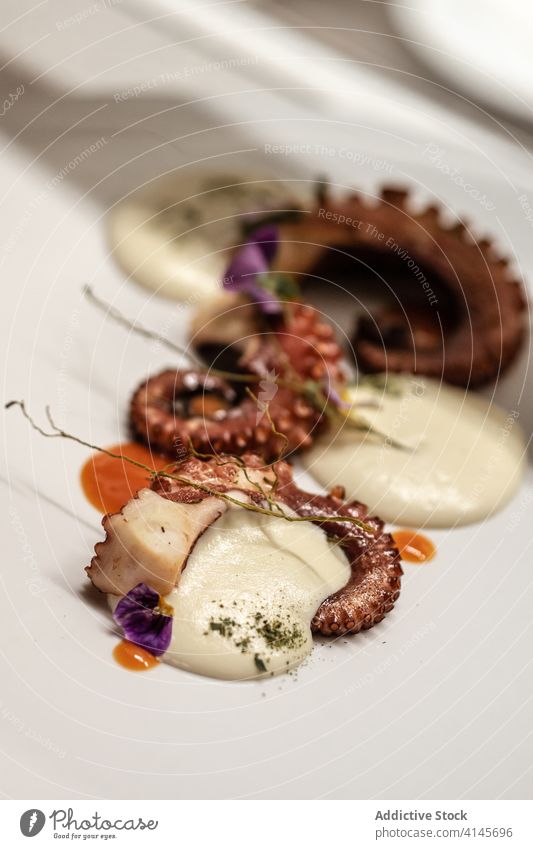 Oktopustentakel mit Sahnesauce Octopus Tentakel Saucen Teller Speise Restaurant dienen Blütenblatt Haute Cuisine lecker schmackhaft Portion Blume geschmackvoll