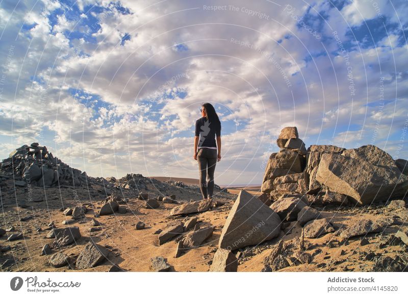 Unbekannter Tourist erkundet malerische Wüste mit unförmigen Steinen bei Tageslicht erkunden wüst Natur Tourismus spektakulär idyllisch Sand holprig Landschaft