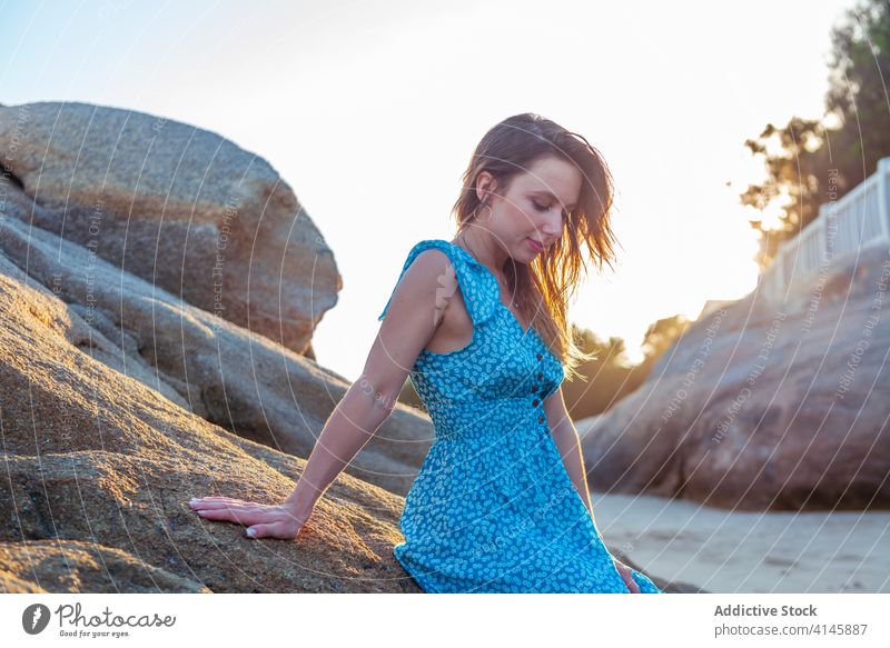 Stilvolle junge Frau lehnt an einer riesigen Klippe an einem Sommertag sich[Akk] entspannen anlehnen Felsen Reisender genießen Glück Haare berühren Seeküste