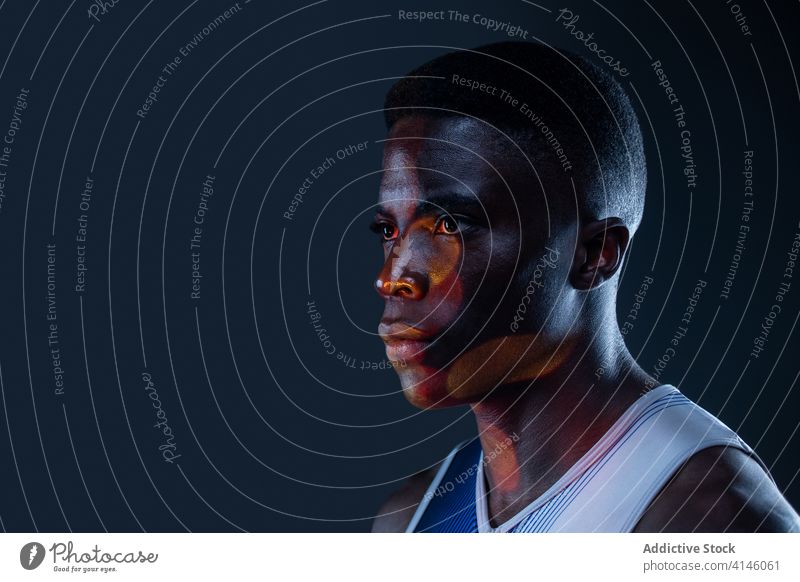 Selbstbewusster schwarzer Sportler in Neon-Beleuchtung Athlet selbstbewusst brutal wettbewerbsfähig Mann Bestimmen Sie Porträt neonfarbig rot aktiv physisch