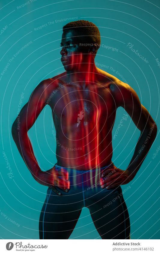 Shirtless Sportler stehen in bunten Studio Läufer Athlet ohne Hemd muskulös Mann Bestimmen Sie selbstbewusst aktiv physisch neonfarbig jung schwarz