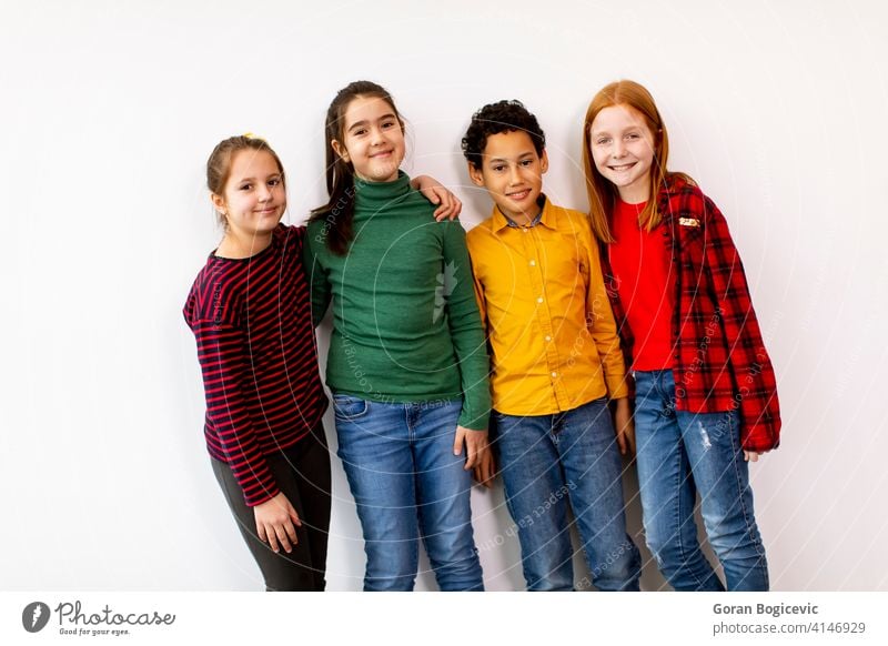Porträt der niedlichen kleinen Kinder in Jeans Blick auf die Kamera und lächelnd, stehen gegen weiße Wand Kaukasier Junge Schule Mädchen Frau Kindheit männlich