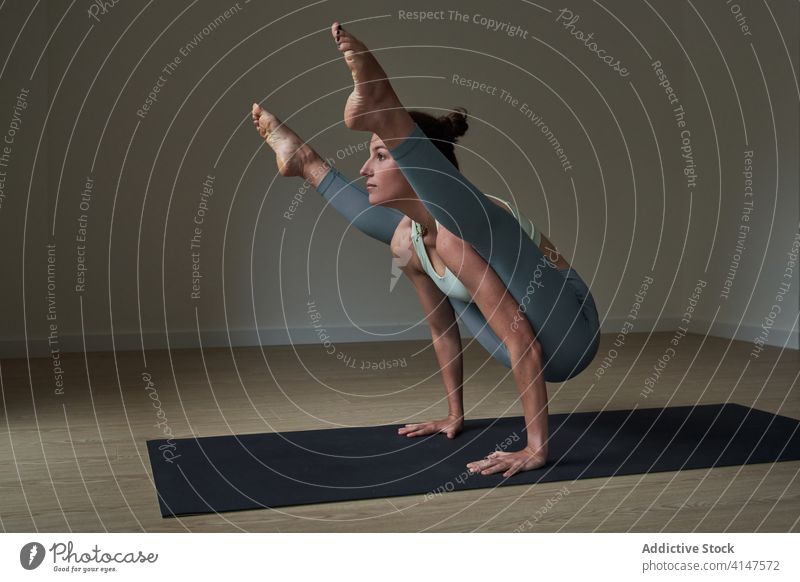 Fröhliche Sportlerin, die ihre Konzentration bei der Yoga-Pose Tittibhasana verbessert Frau üben ashtanga vinyasa Glühwürmchen Glück stark Athlet Lächeln