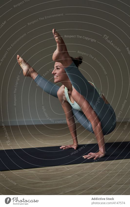 Fröhliche Sportlerin, die ihre Konzentration bei der Yoga-Pose Tittibhasana verbessert Frau üben ashtanga vinyasa Glühwürmchen Glück stark Athlet Lächeln