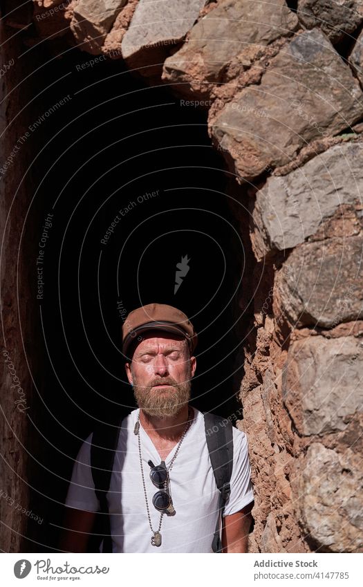 Männlicher Tourist beim Besuch eines historischen Steingebäudes Reisender Hipster Mann alt antik Bogen Torbogen Türöffnung Architektur Ausflug Sightseeing