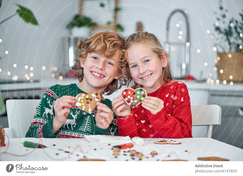 Fröhliche Geschwister mit herzförmigen Lebkuchenplätzchen Kind Weihnachten Keks Glück vorbereiten machen Zusammensein handgefertigt Herz Feiertag Liebe