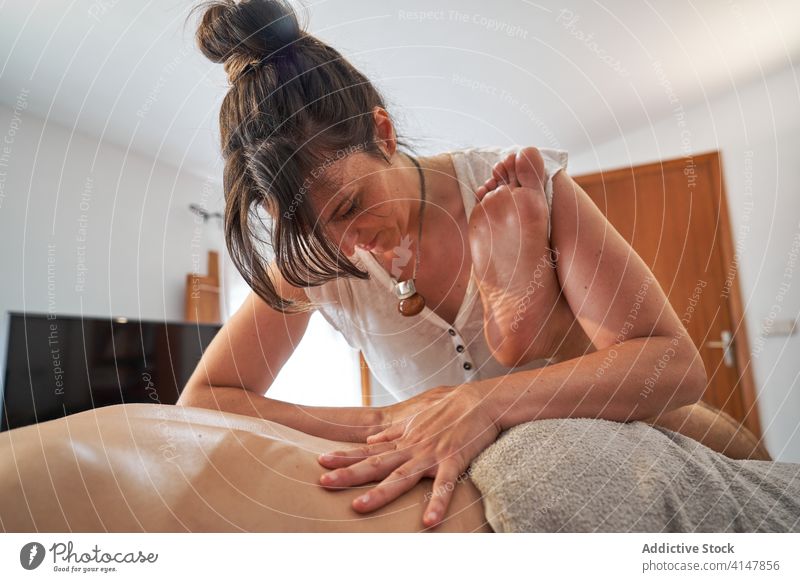 Masseurin massiert das Bein eines entspannten Kunden Massage Salon Frau kneten Körper Pflege Gesundheit Therapeut Klient Tisch Therapie geduldig ruhig Spa