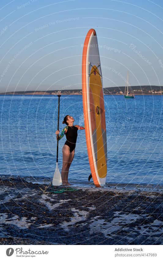 Frau mit Paddleboard am Ufer im Meer Paddelbrett Surfer Pumpe Strand Gerät Wasser Holzplatte Meeresufer Sport MEER sich[Akk] entspannen Küste Aktivität stehen